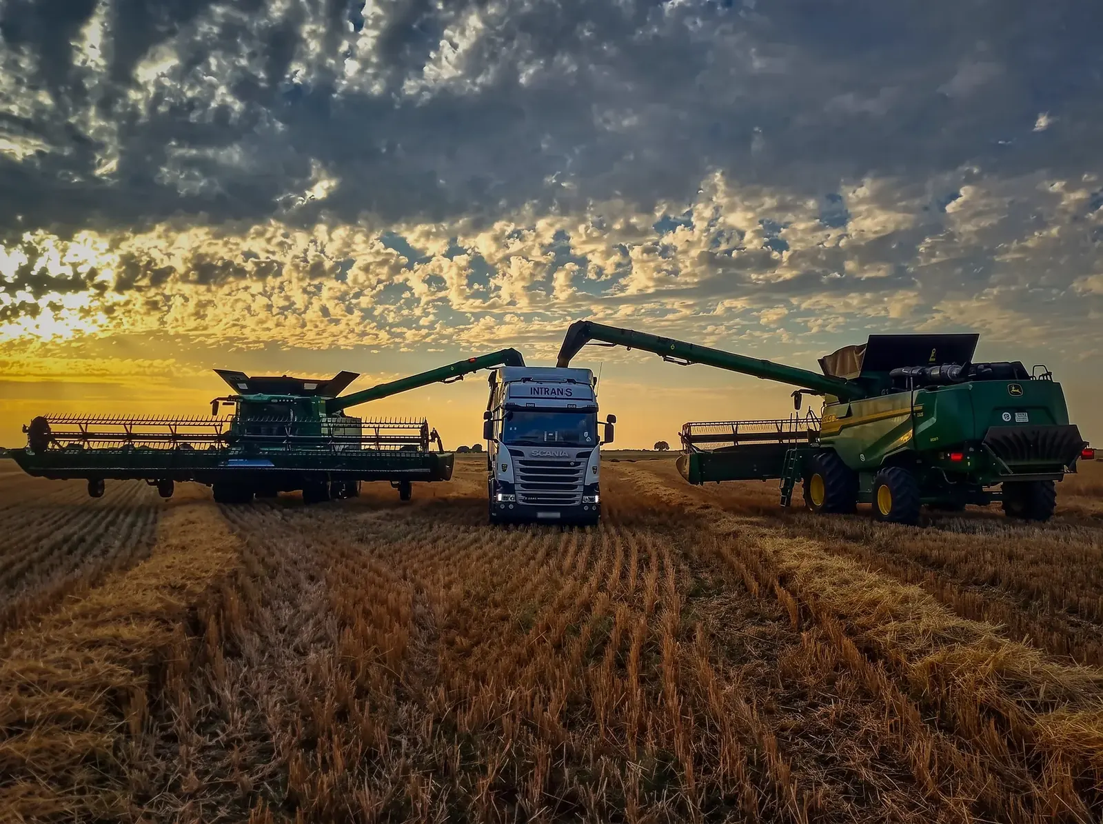 Fotografía ganadora: el Scania de Intrans entre dos cosechadoras al atardecer