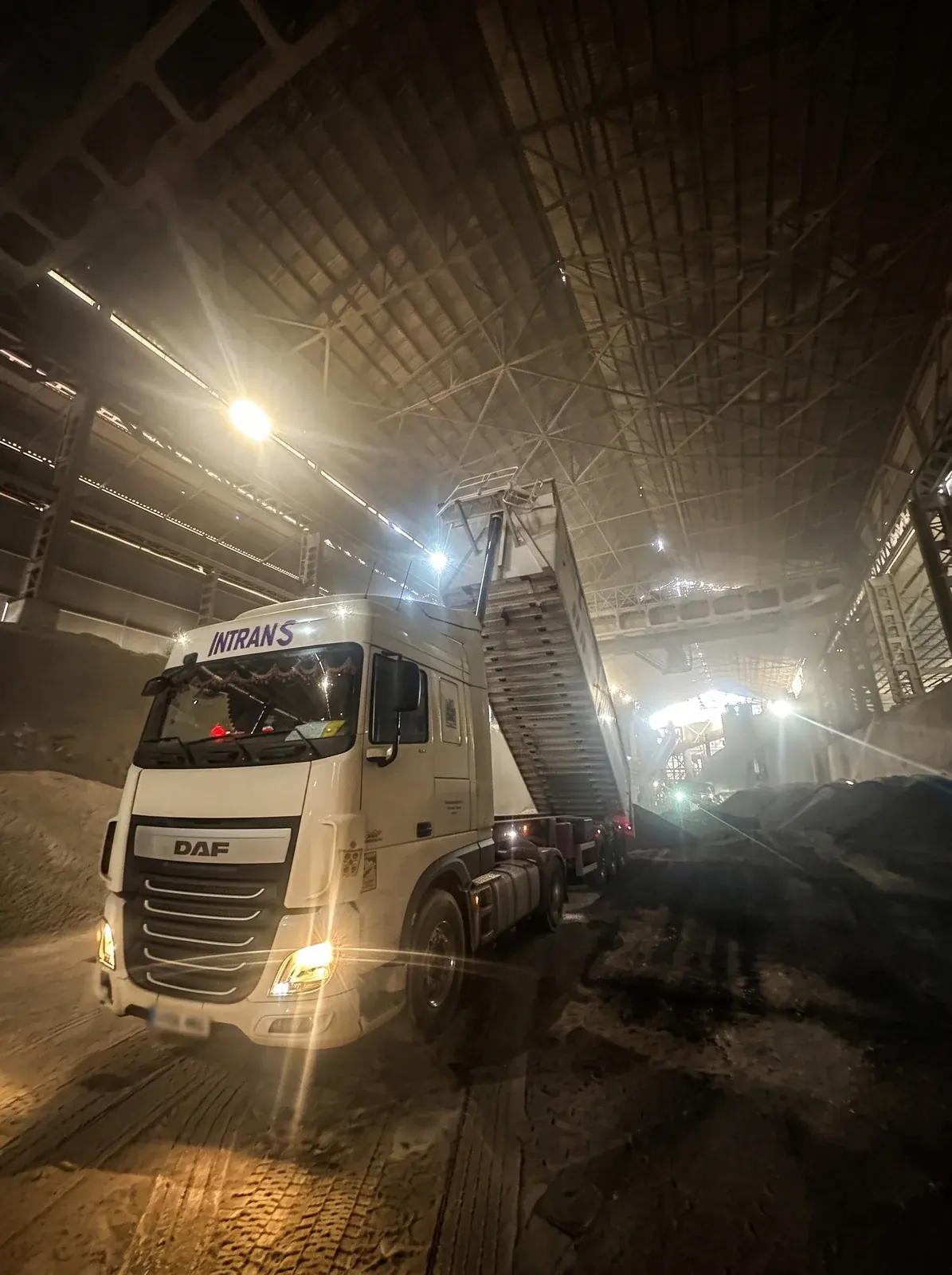 Camión basculante de Transportes Infante Herrador descargando en una nave