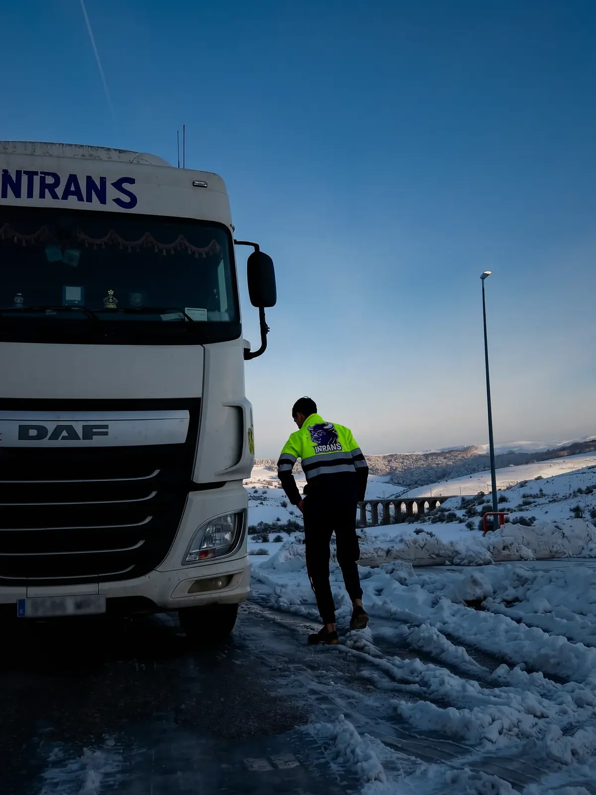Conductor de Intrans junto al camión en una carretera nevada